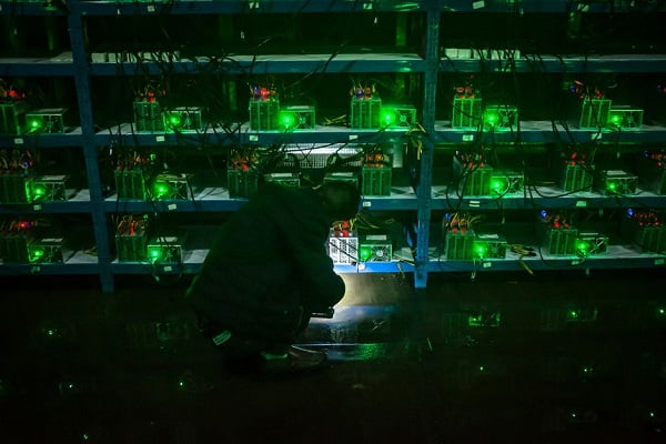 Сотрудник проверяет неисправную машину по добычи криптовалюты во время ночной смены